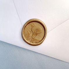 an envelope with a waxed stamp on it and a flower in the center is shown