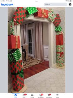 an arch made out of wrapped presents in front of a door