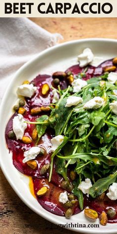 beet carpaccio salad with goat cheese and pistachio sauce on a white plate