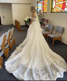 a woman in a wedding dress standing next to some chairs