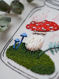 a close up of a piece of embroidery with mushrooms on it