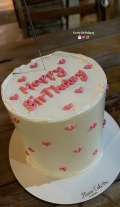 a white cake with pink frosting and the words happy birthday on it