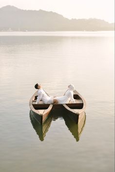 two people are sitting in a boat on the water