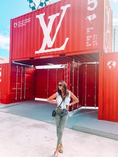 a woman standing in front of a red shipping container