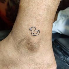 a small tattoo on the ankle of a person with a rubber ducky in it