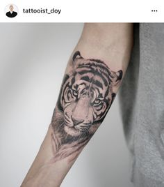 a man's arm with a tiger tattoo on the left side of his arm