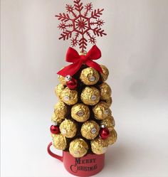 a christmas tree made out of chocolates in a red mug with a snowflake on top