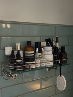 a shelf filled with lots of different types of skin care products on top of a tiled wall