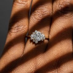 a woman's hand with a diamond ring on top of her finger and shadow