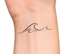 a woman's wrist with a small wave tattoo on the left side of her arm