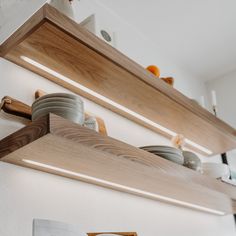 two wooden shelves with plates and bowls on them