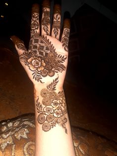 a person's hand with hennap on it and some flowers around the wrist