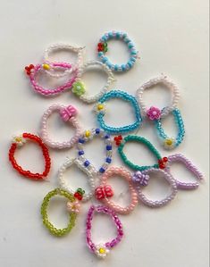 many different colored bracelets on a white surface