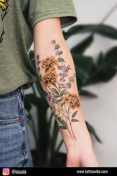 a woman's arm with flowers and leaves tattooed on the left side of her arm