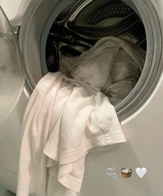 an open washing machine with clothes in it