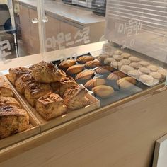 a display case filled with lots of different types of pastries in front of a window