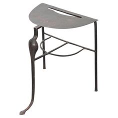 an iron stool with a curved seat and foot rest on the bottom, against a white background