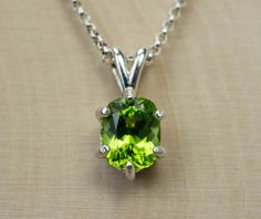 This is a beautiful and natural Peridot from Pakistan set in Sterling Silver. This amazing stone has the perfect deep lime green color that many want to see in Peridot and is one of those underrated stones that has a quite remarkable history. This Peridot has a great luster, and clarity as well. Peridot is August's Birthstone. This nicely sized 9mm x 7mm Cushion Peridot weighs 2.050cts and is beautifully accented by a 6 prong setting and will go great with most styles or occasions. They will eve Polished Peridot Jewelry, Green Peridot Necklace For May Birthstone, Oval Peridot Green Jewelry, Oval Green Peridot Jewelry, Green Oval Peridot Jewelry, Green Peridot Gemstones As Birthstones, Green Peridot Gemstones For Gifts, Lime Green Peridot Necklace For May Birthstone, Green Peridot Birthstone Gemstones