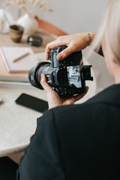 a woman holding a camera in front of her face