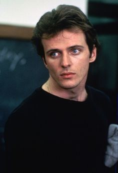 a close up of a person wearing a black shirt and looking at the camera with an intense look on his face