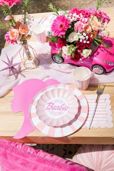 a table topped with pink flowers and plates