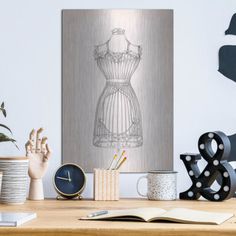 a wooden table topped with an art piece next to a clock and other items on top of it