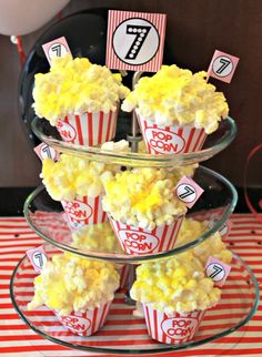 popcorn cupcakes are stacked on top of each other in red and white striped paper