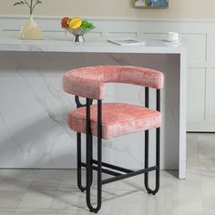 a pink chair sitting on top of a white counter