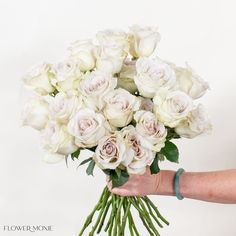 a person holding a bouquet of white roses