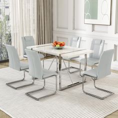 a dining room table with chairs and fruit on it