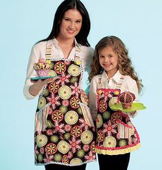 two women in aprons are posing for the camera