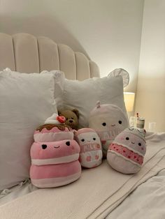 stuffed animals are sitting on a bed with pillows