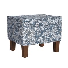 a blue and white ottoman sitting on top of a wooden leg rest with an intricate pattern