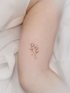 a small rose tattoo on the left arm