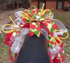 a red and green christmas wreath on top of a mailbox