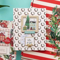 christmas cards with holly wreaths on them and a house in the middle, surrounded by greenery