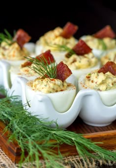 deviled eggs with bacon and dill garnish on a serving tray for appetizers