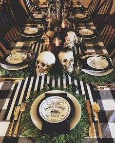 a table set for halloween dinner with skulls on it