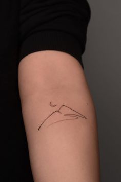 a woman's arm with a small tattoo on the left side of her arm