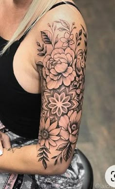 a woman with a black and white flower tattoo on her arm holding a cell phone