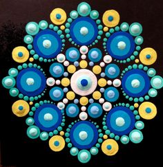 a circular design made out of blue, yellow and white circles on a black surface