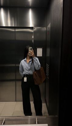 a woman taking a selfie in an elevator