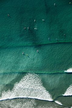 two surfers are riding the waves in the blue ocean, top view from above