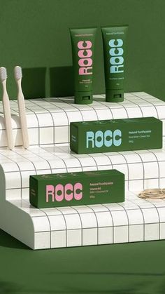 three toothbrushes are sitting on top of some boxes that say roocc