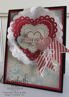 a close up of a card with a heart and ribbon attached to it's side