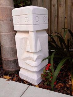 a large white statue sitting next to a tree