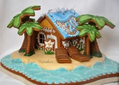 a gingerbread house decorated with palm trees and beach decor on top of an island