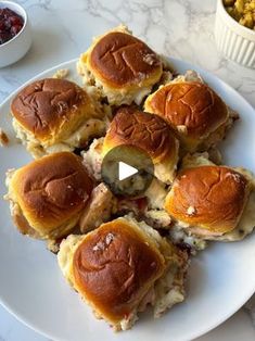 a white plate topped with sliders covered in cheese