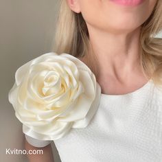 a woman holding a white flower in her right hand