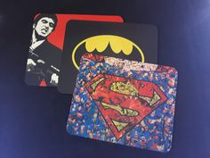 two coasters with superman logos on them and one has the image of elvis presley